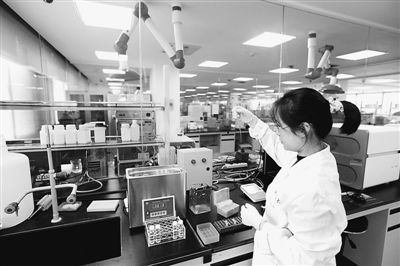 中國科大生命科學(xué)實驗中心的技術(shù)人員在科學(xué)儀器前做測試分析。